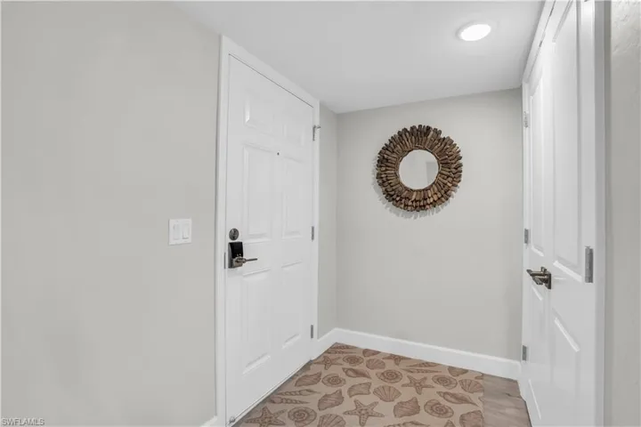 Foyer with light hardwood / tile wood-style flooring