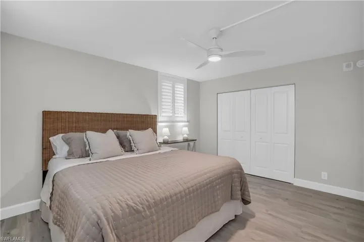 Bedroom with ceiling fan,a closet, and hardwood tile wood-style flooring