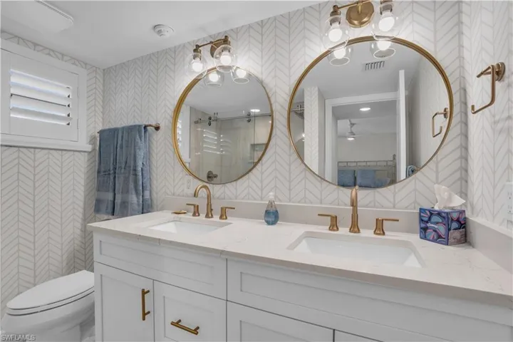 Bathroom with dual sinks, toilet, and large vanity