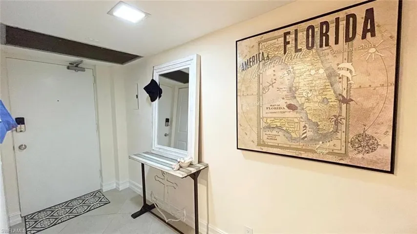 Corridor featuring tile patterned flooring and baseboards
