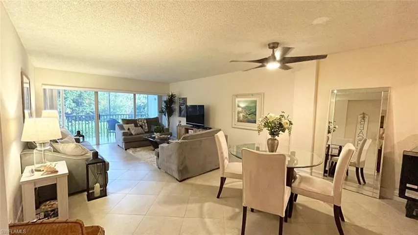Dining space with ceiling fan, light tile patterned flooring, and a textured ceiling