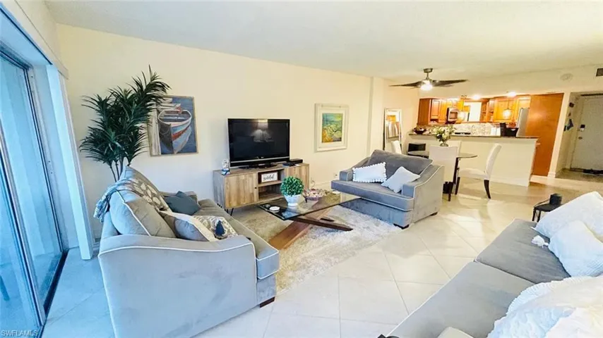 Living room featuring light tile patterned floors and a ceiling fan