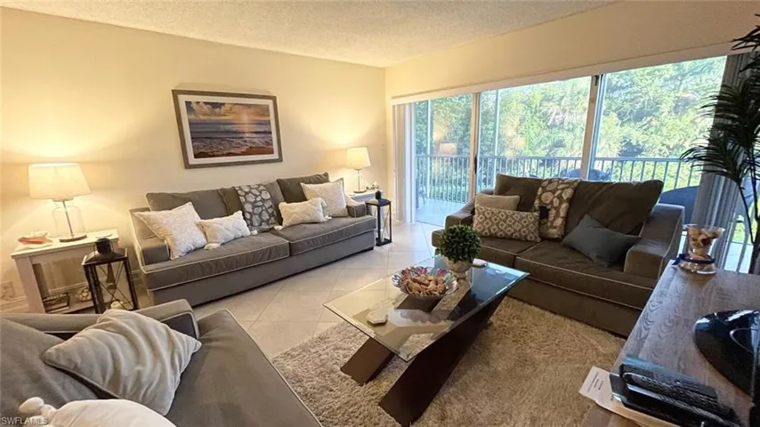 Living area with light tile patterned floors and a textured ceiling