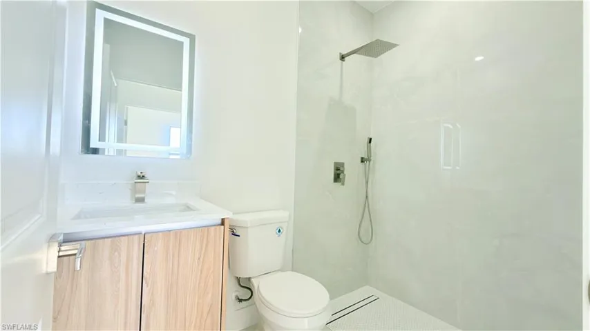 Full bathroom featuring vanity and a marble finish shower
