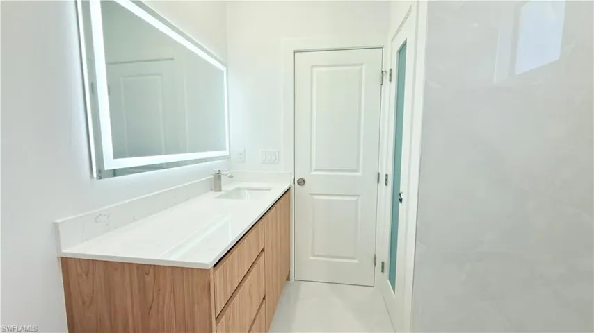 Full bath featuring vanity and light tile patterned floors