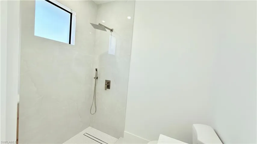 Bathroom with a marble finish shower