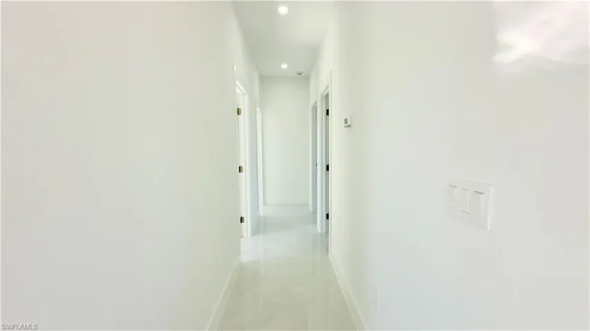 Corridor with baseboards and recessed lighting