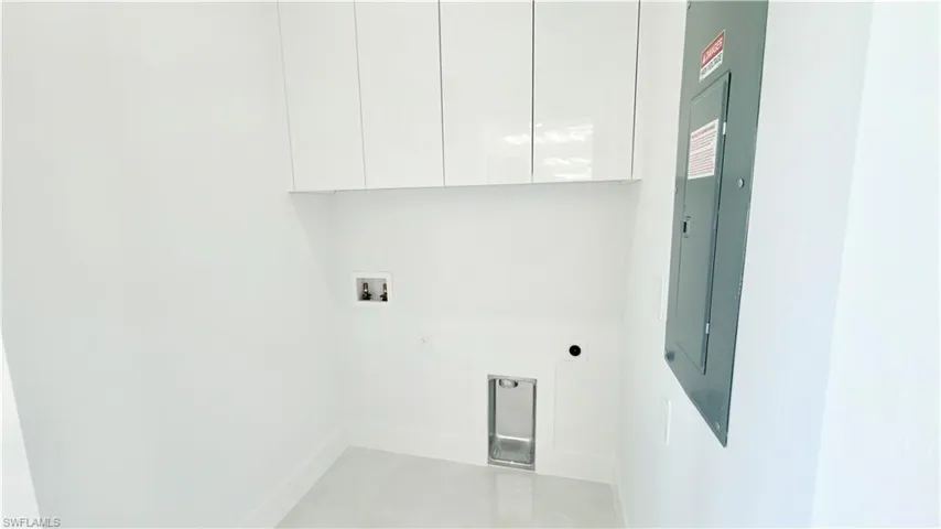 Laundry room with electric panel, hookup for an electric dryer, washer hookup, and cabinet space