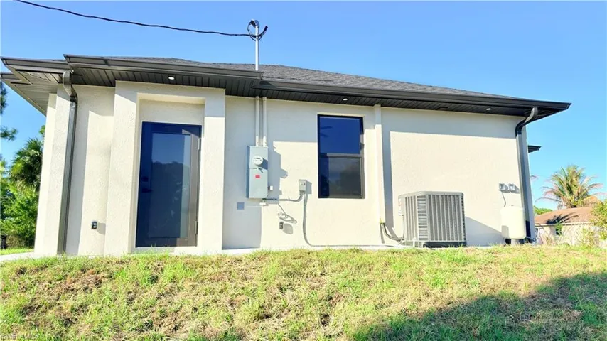 Back of property featuring stucco siding and a lawn