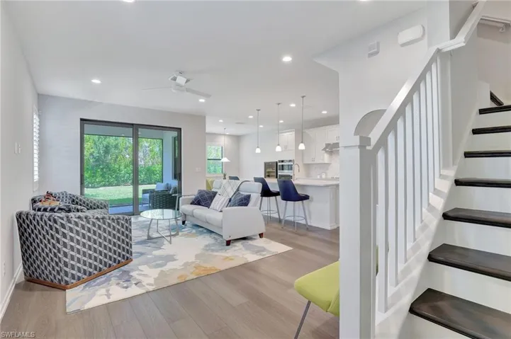 Living room with ceiling fan and light hardwood / wood-style floors