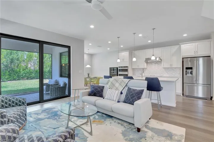 Living room featuring ceiling fan, light wood-type flooring, and sink