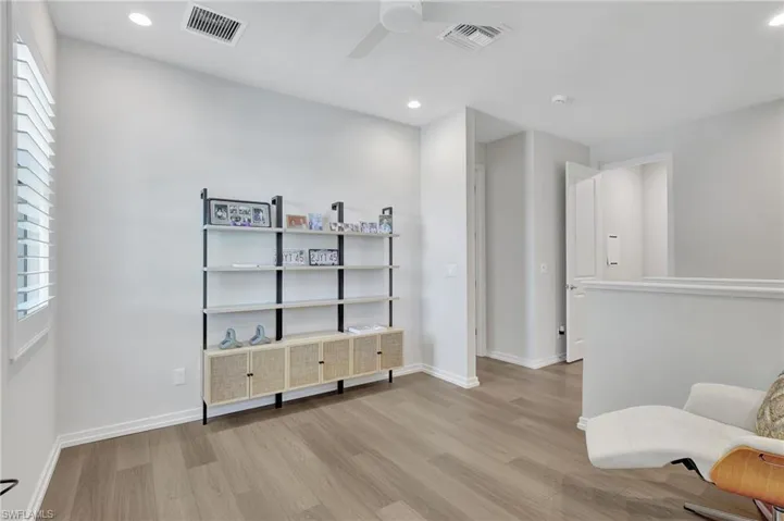 Sitting room with ceiling fan and light wood-type flooring