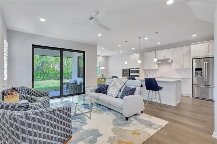 Living room featuring light hardwood / wood-style flooring, ceiling fan, and sink