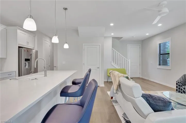 Kitchen featuring high quality fridge, ceiling fan, white cabinets, and pendant lighting