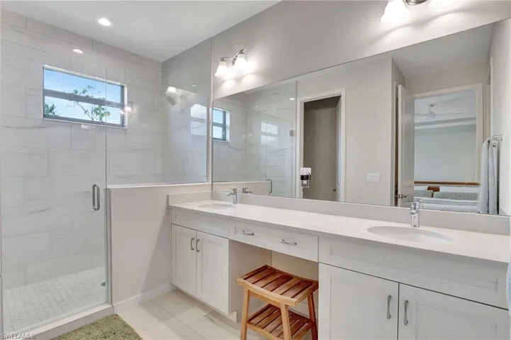 Bathroom with tile patterned flooring, vanity, and a shower with shower door