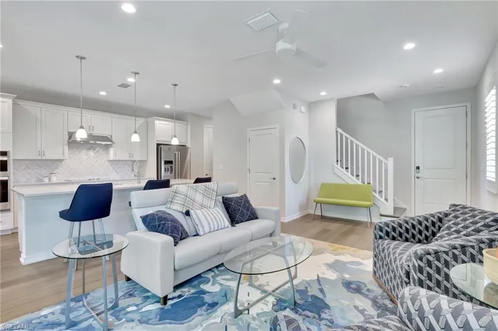 Living room with ceiling fan, sink, and light wood-type flooring