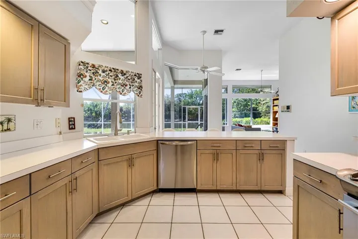 Kitchen with visible vents, ceiling fan, light countertops, stainless steel dishwasher, and a sink
