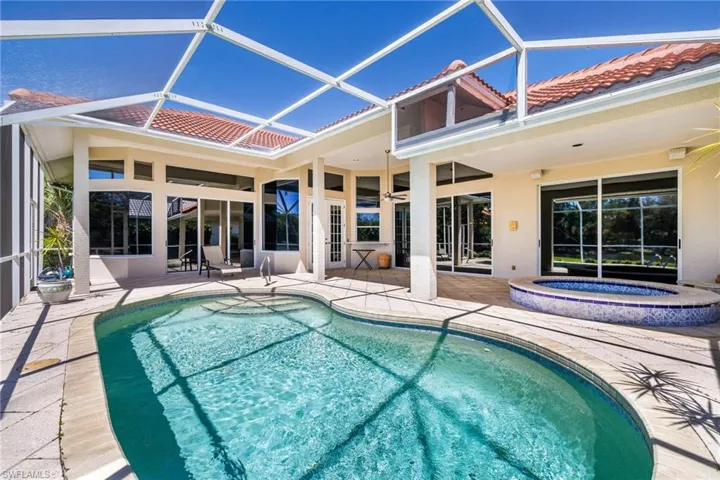 Outdoor pool with a lanai, ceiling fan, a patio, and an outdoor hot tub