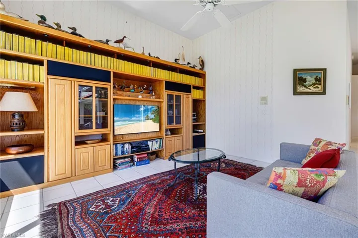 Living area with tile patterned floors and a ceiling fan