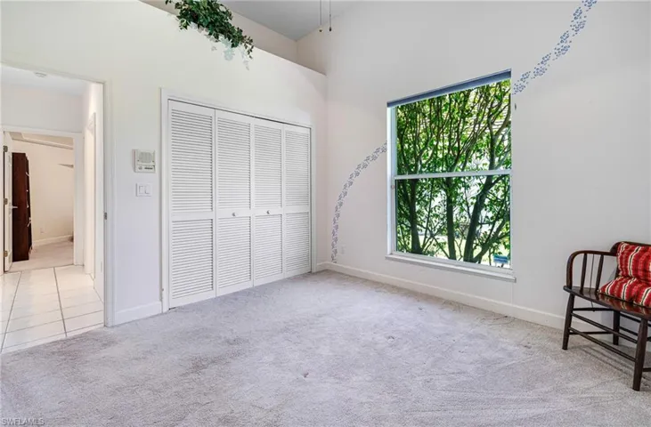 Carpeted bedroom featuring a closet, tile patterned flooring, and baseboards