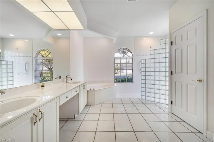 Bathroom featuring a sink, walk in shower, a bath, and tile patterned floors