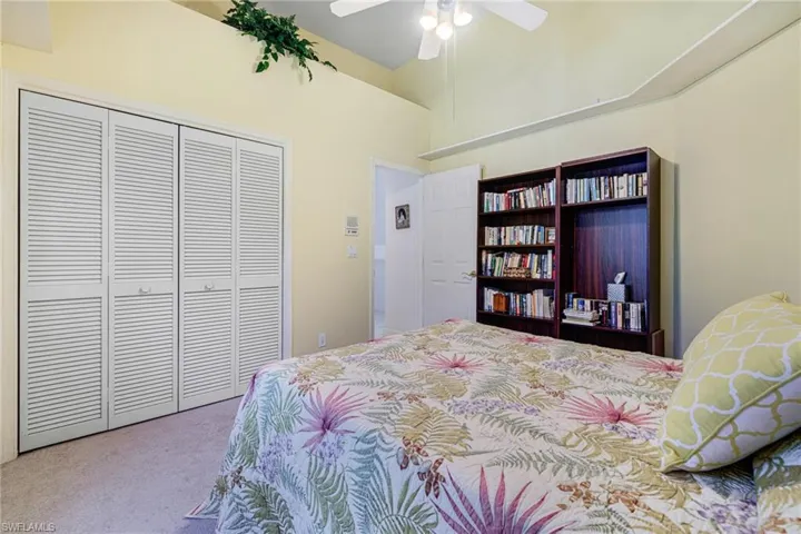 Bedroom with a closet, carpet, and a ceiling fan