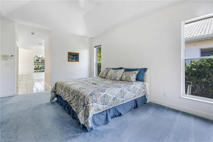 Bedroom featuring lofted ceiling, carpet, baseboards, and ceiling fan