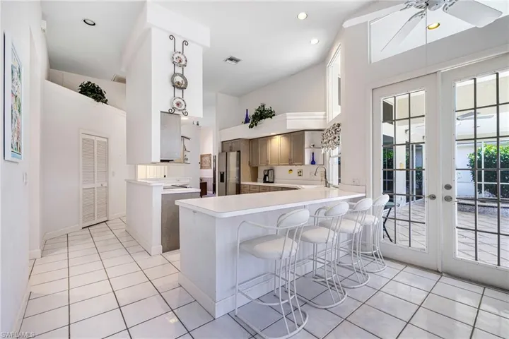Kitchen featuring a peninsula, visible vents, stainless steel fridge, and a sink
