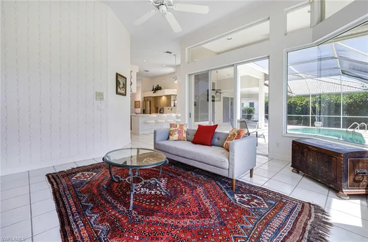 Tiled living area featuring baseboards and ceiling fan