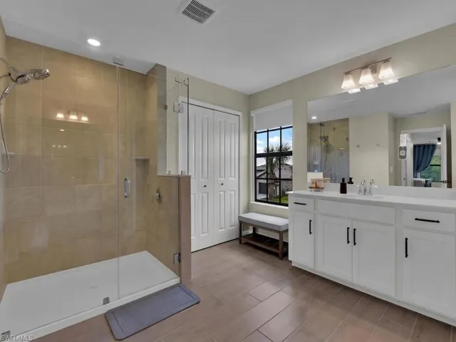 Upgraded frameless shower, added tile up to ceiling, large bi-fold closet and two sinks/vanities