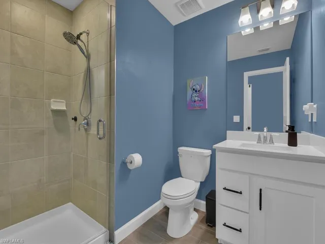 Walk-in frameless door shower adjoined to bedroom