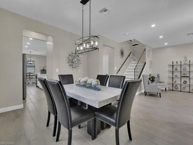 Kitchen featuring white shaker cabinets, white quartz countertops, large island with seating and pantry