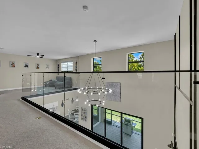 The property features a spacious open-concept design with a glass railing overlooking the lower level
