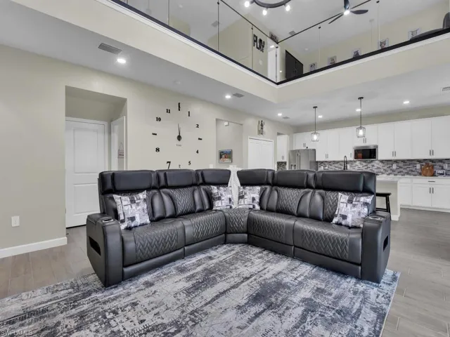 The property features an open-concept living space with high ceilings and a view of an upper level