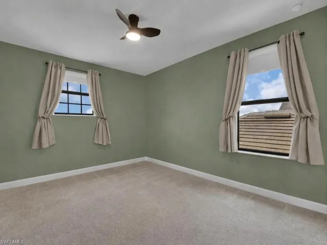 Bedroom in the corner of the home featuring two windows, bringing in natural light