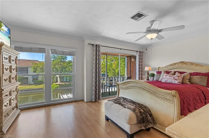 Bedroom with light wood-type flooring, access to exterior, ornamental molding, ceiling fan, and a textured ceiling