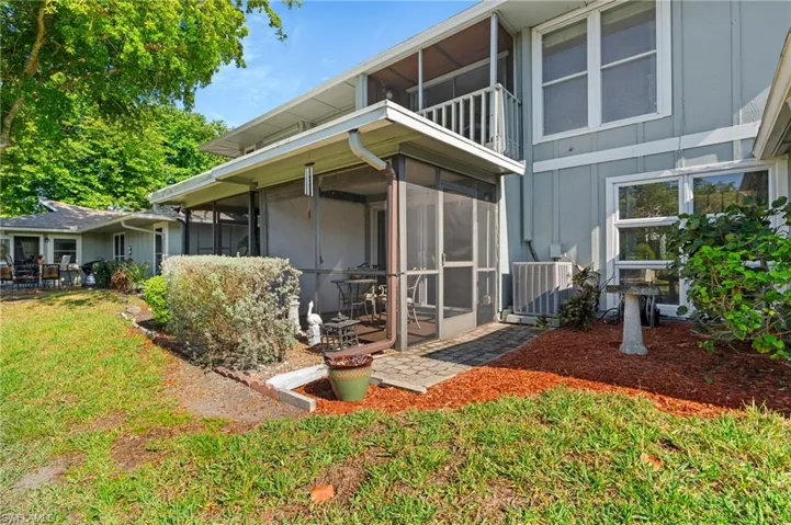Back of house featuring a sunroom, a yard, and board and batten siding