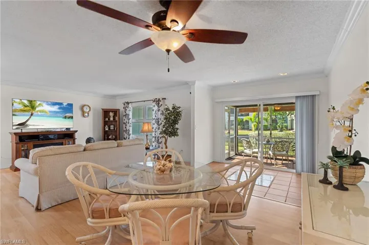 Dining space featuring crown molding, a textured ceiling, a ceiling fan, and light wood-type flooring