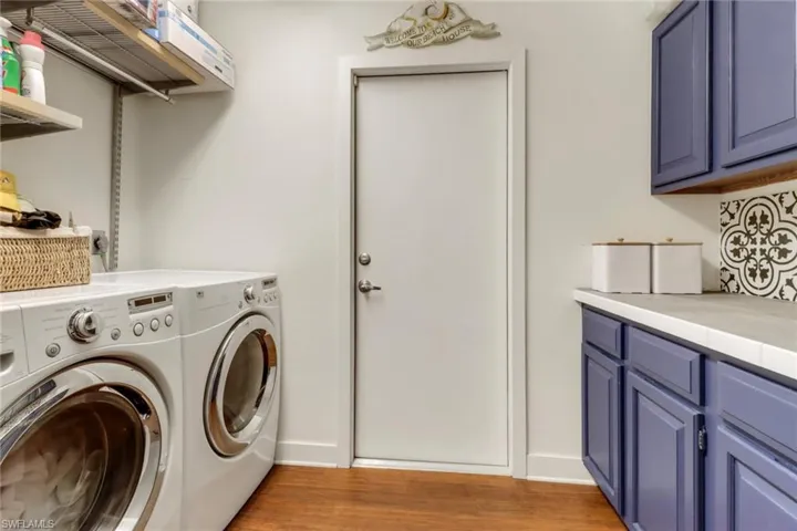 Laundry Room, wood cabinets, stone counters, door leads to the garage.