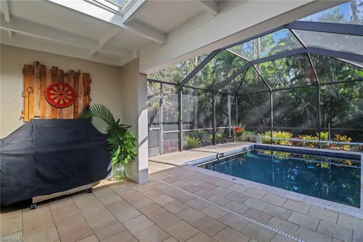 Outdoor pool with a patio, a lanai, and a grill
