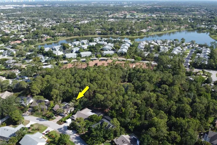 Aerial view of property and surrounding area featuring a nearby body of water and preserve behind the home