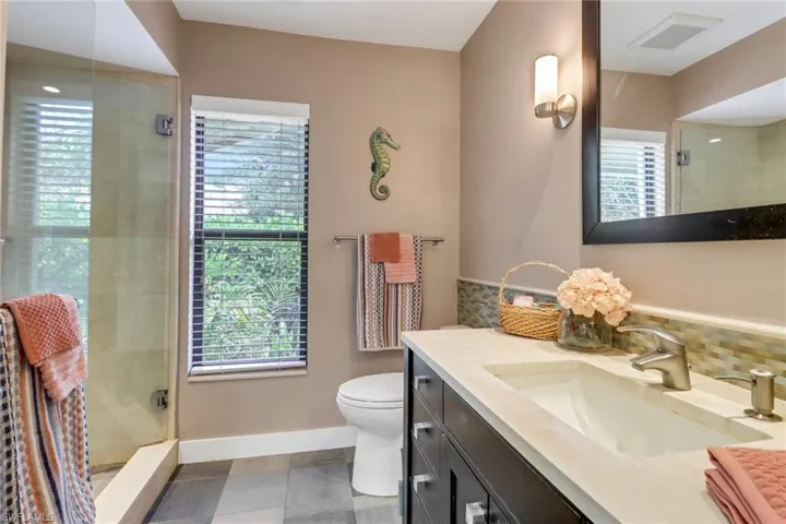 Second Bath custom wood cabinets, travertine vanitie , mirror and lights, toto water closet impact window