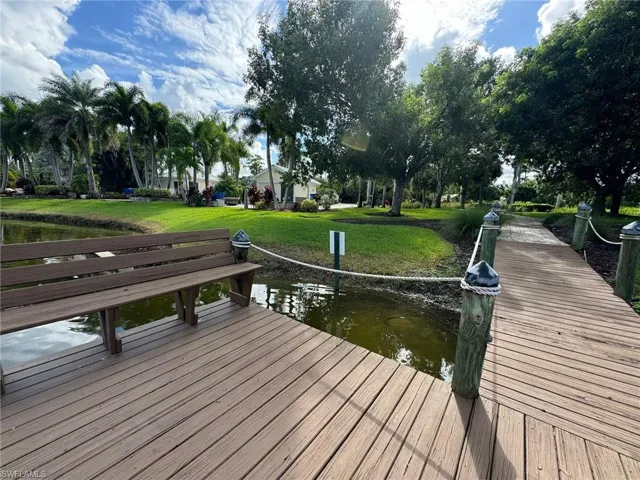Dock area with a water view and a lawn