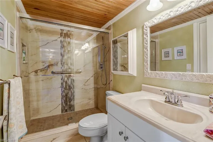 Bathroom with vanity, toilet, a shower with door, and wood ceiling