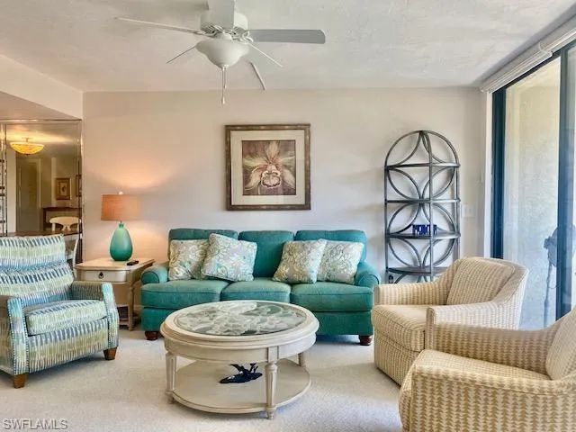 Living room featuring carpet floors and ceiling fan