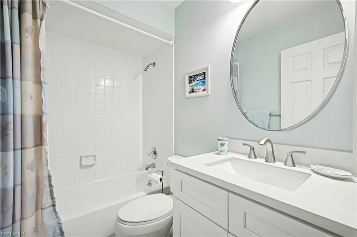 Full bath with shower / bath combo with shower curtain and vanity