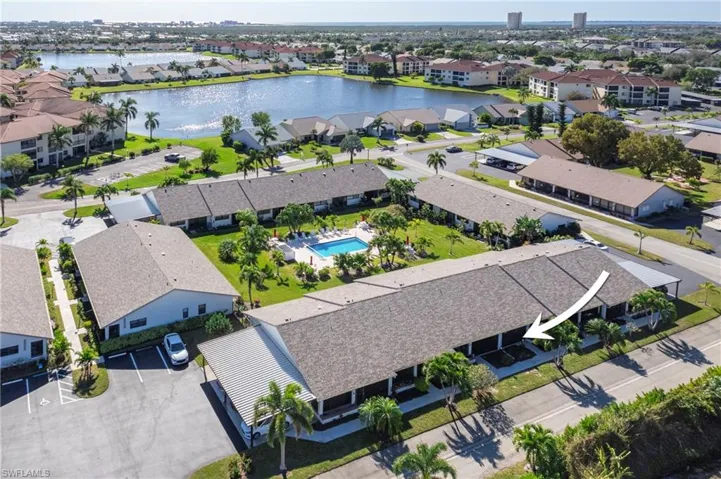 Aerial perspective of suburban area featuring a large body of water and a pool area