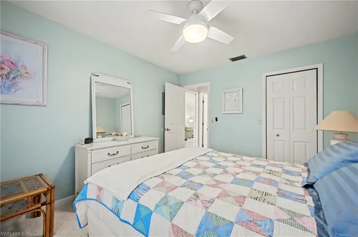 Bedroom with light colored carpet, a ceiling fan, and a closet
