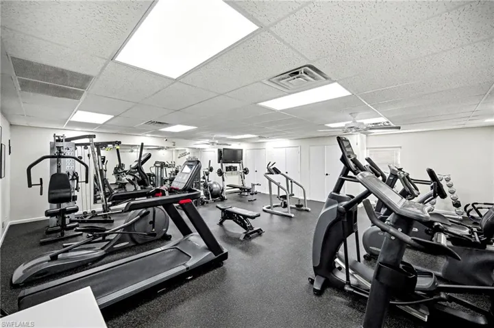 Exercise room with a drop ceiling and a ceiling fan