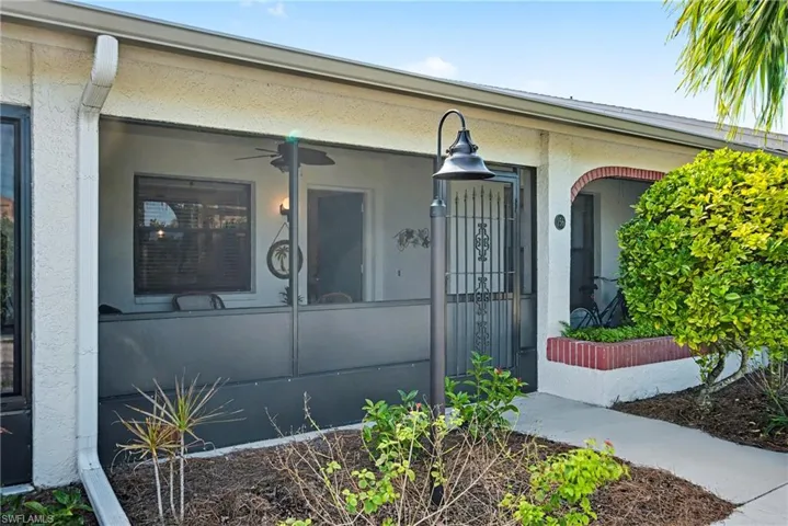 Entrance to property with stucco siding and a ceiling fan
